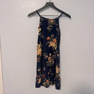 A navy blue flowy dress with floral print and adjustable straps